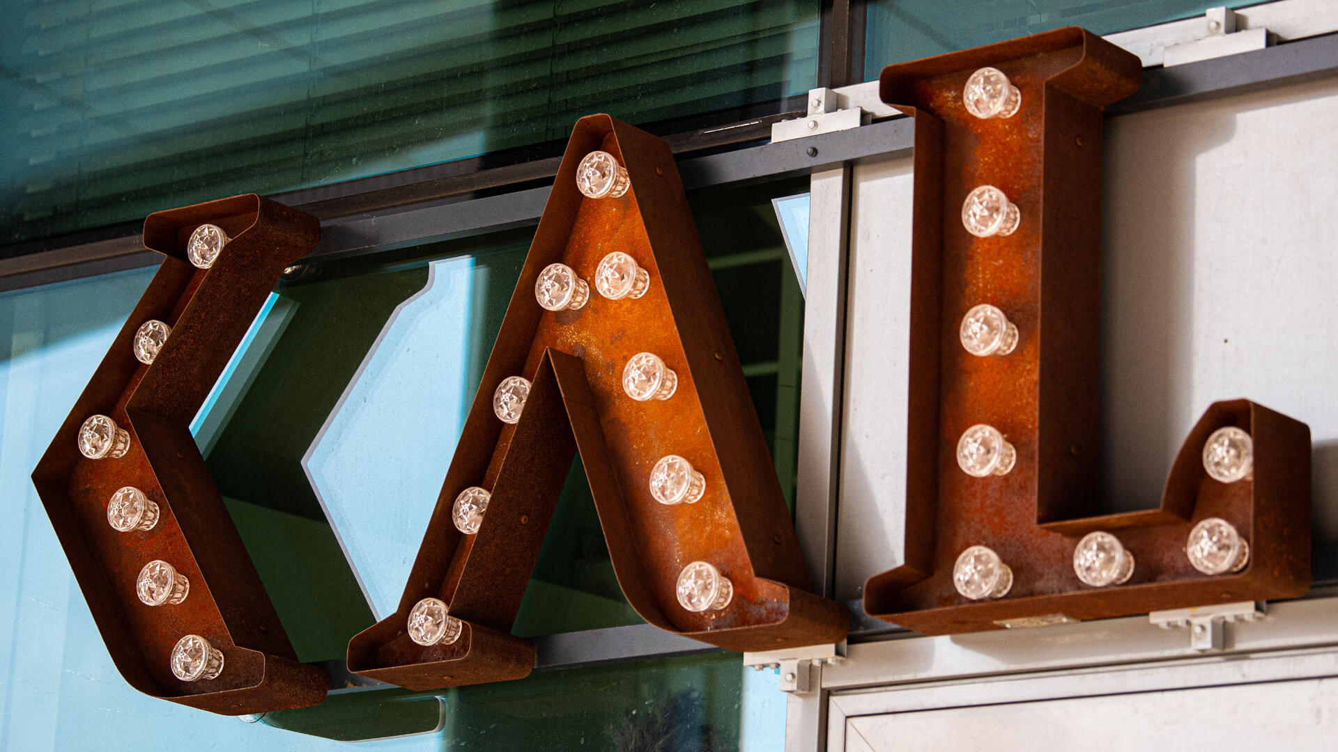 Roestige letters met retro lampen Kalska